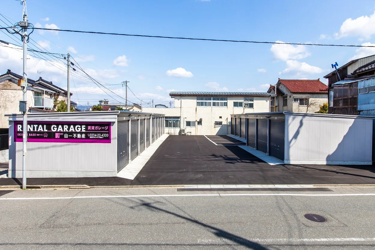 賃貸ガレージの看板と、通路の両側に続く白いガレージ
